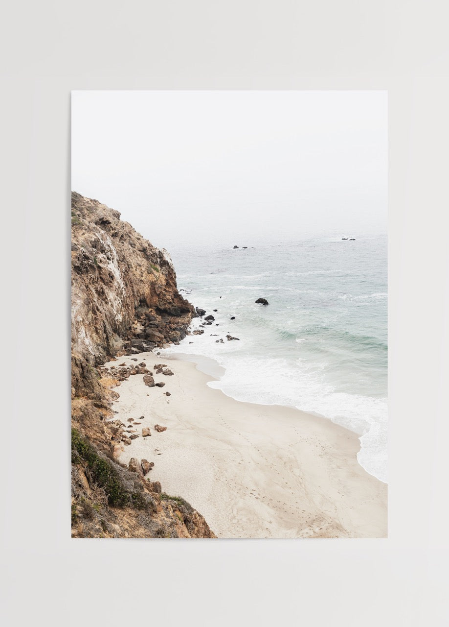 A serene beach view with gentle waves and soft sand.