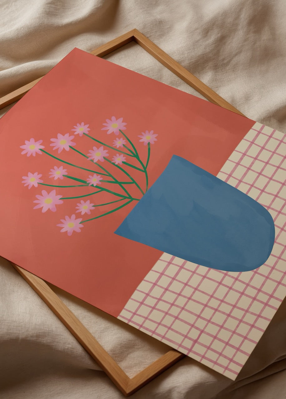 A vibrant blue pot with pink flowers against a warm background.