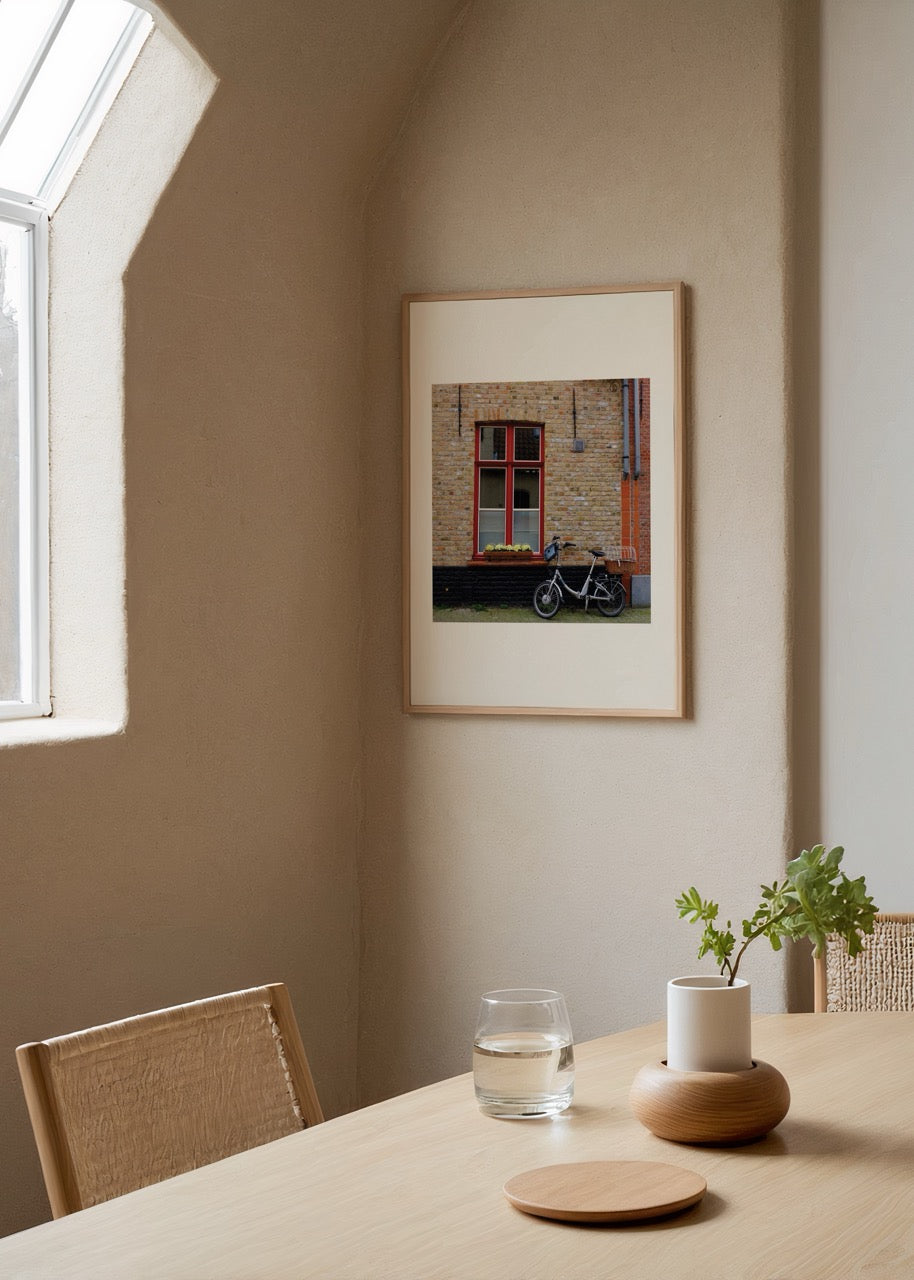 A bicycle beside a window in a charming Brussels brick wall setting.