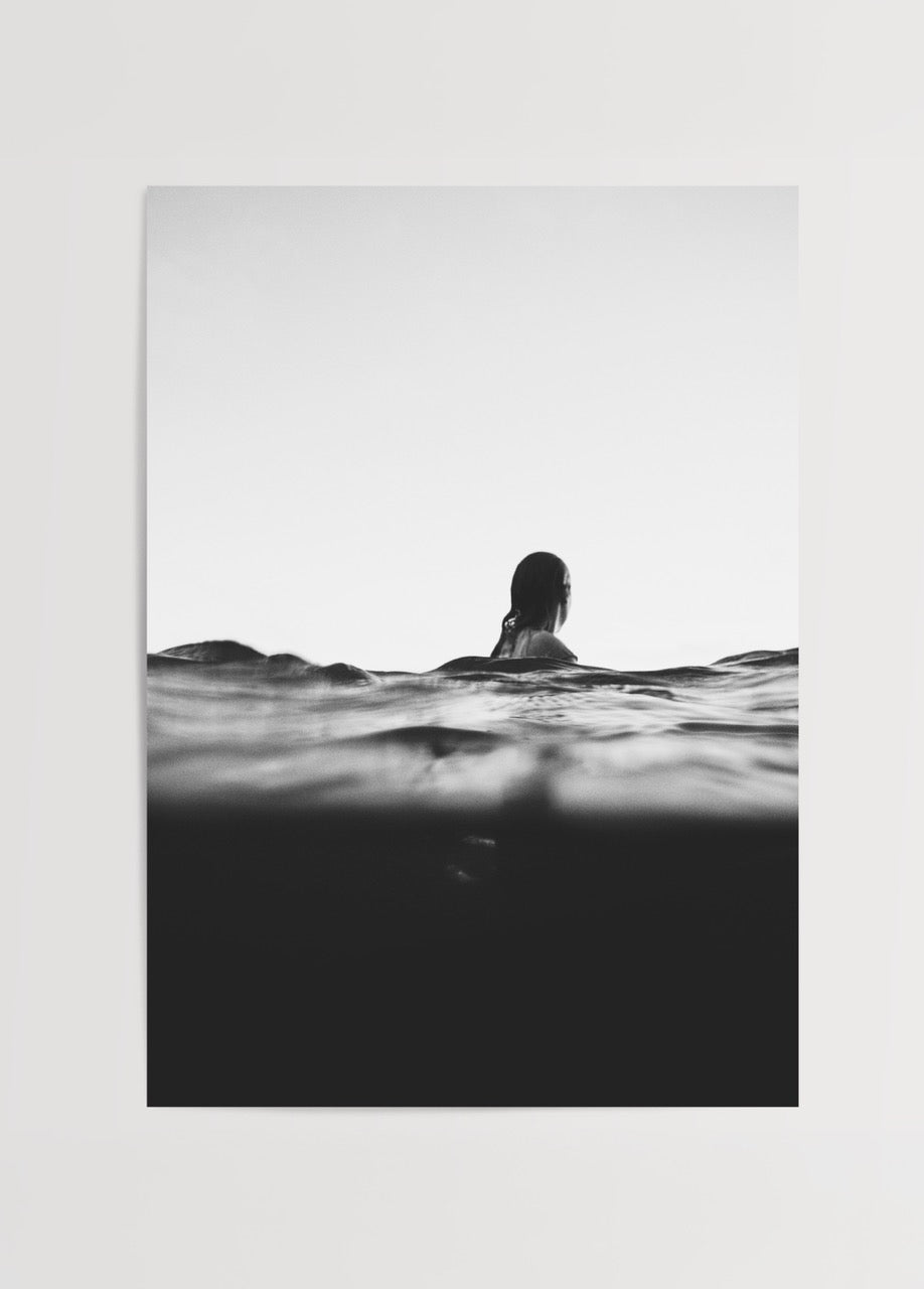 A black and white photograph of a woman in tranquil waters, representing serenity.