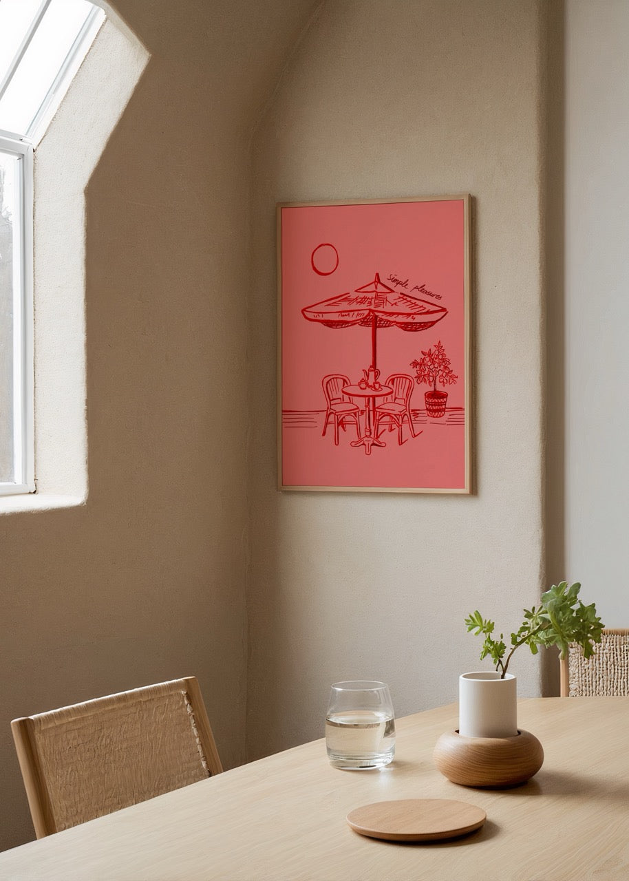Artwork featuring a simple outdoor setting with a table, chairs, and an umbrella in warm tones.