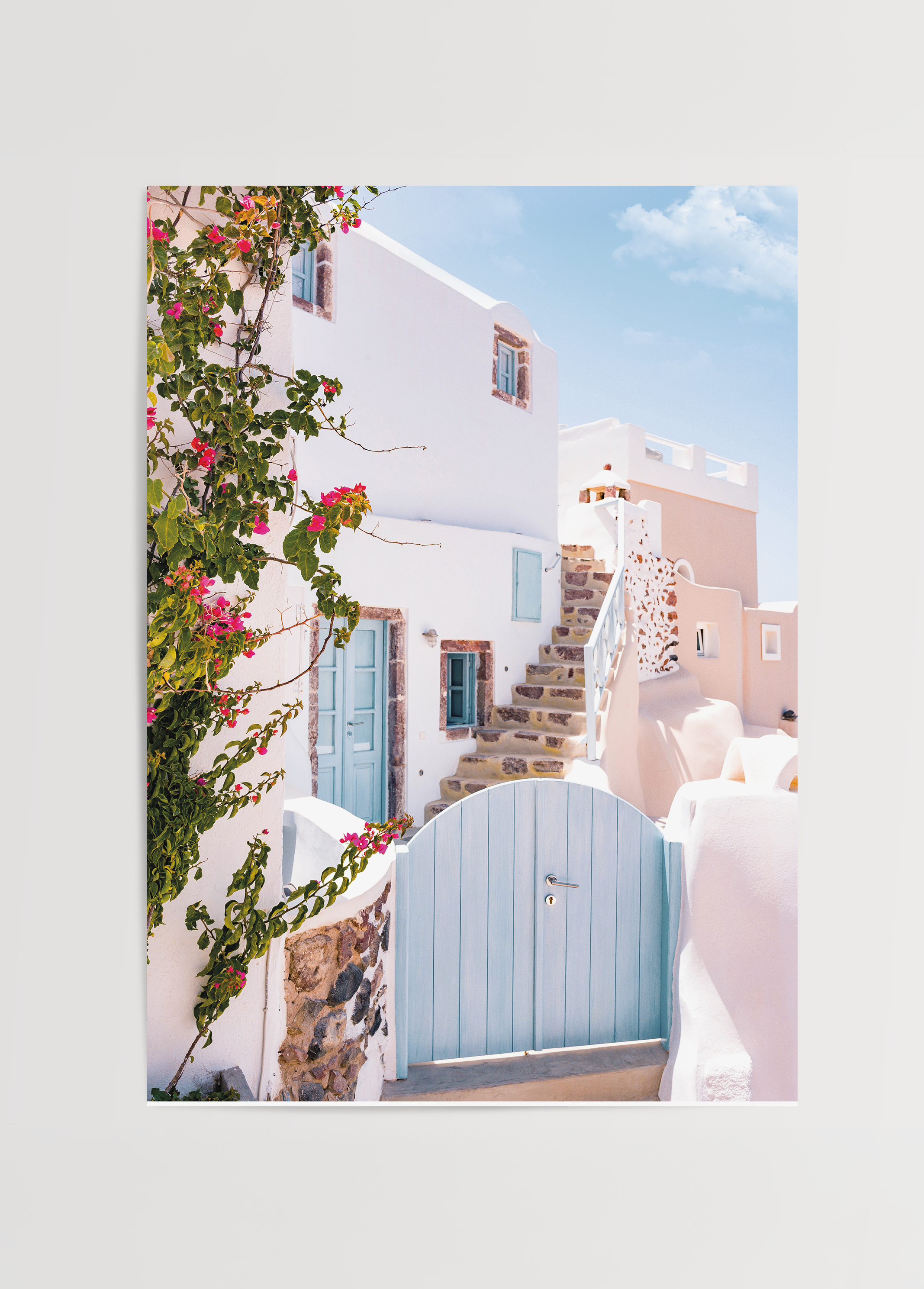 A charming view of Santorini steps with a blue door and pink flowers, perfect for wall art.