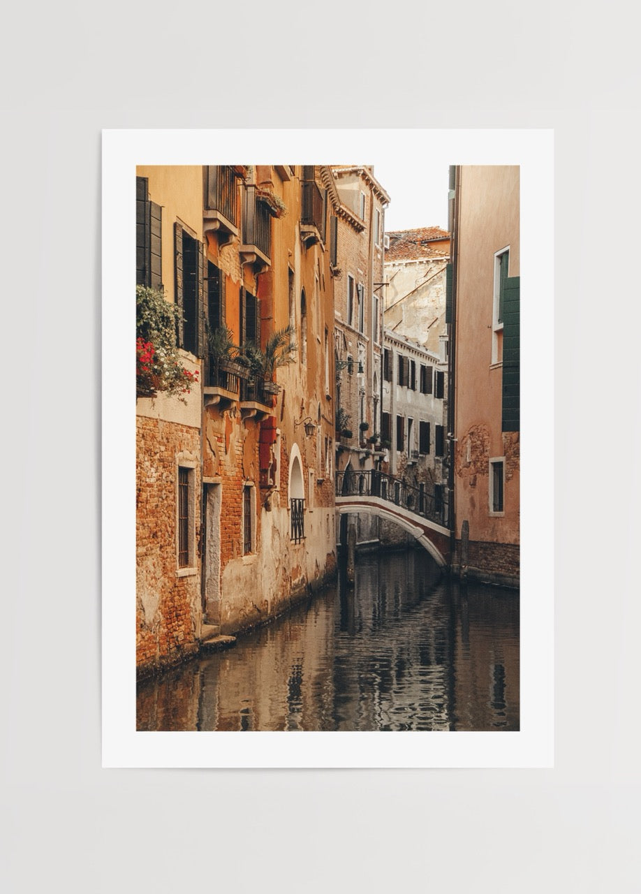 Serene canal scene in Venice with warm tones and reflections.