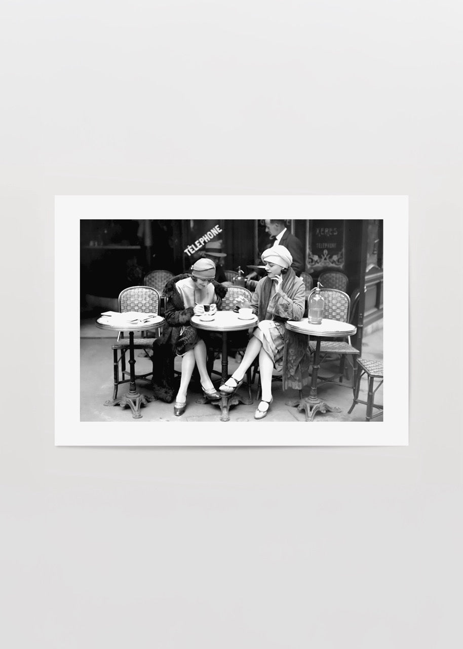 Vintage black and white photograph of two women at a Paris café.