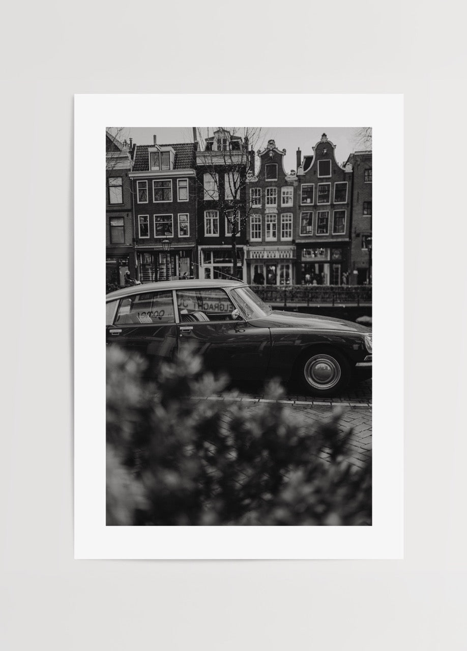 Black and white vintage car photograph in Amsterdam, evoking nostalgia.