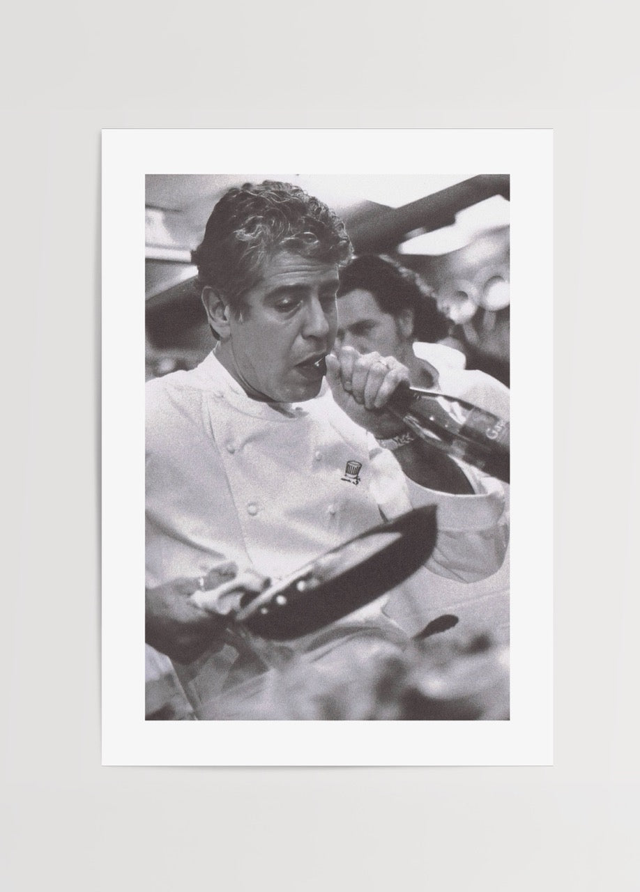 Black and white poster depicting a chef passionately cooking in a kitchen.