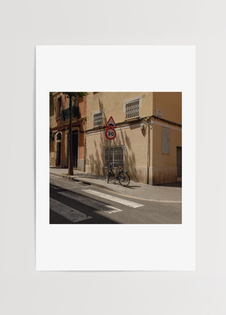 A street scene in Barcelona featuring a bicycle and urban architecture.