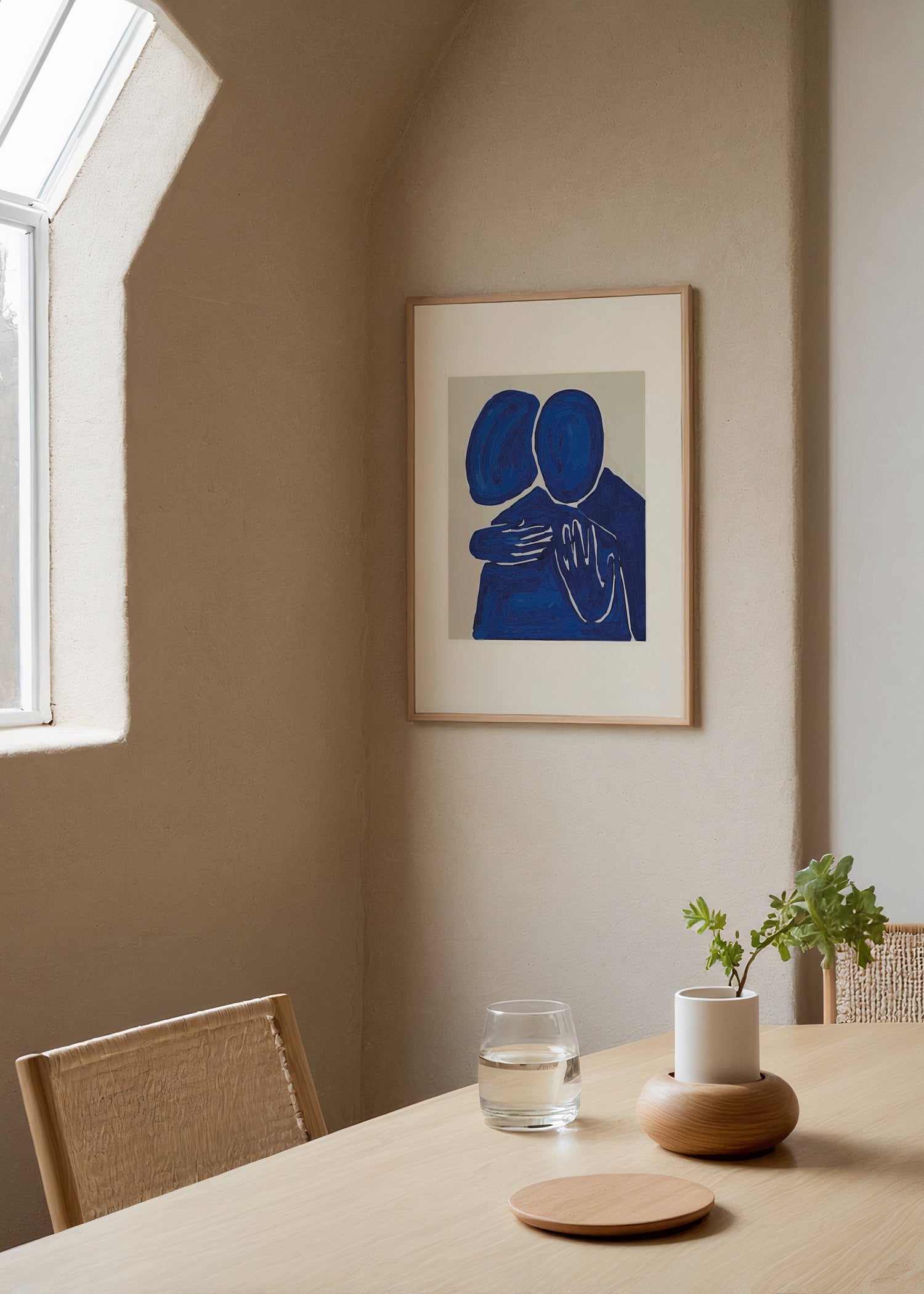 A minimalist artwork depicting two figures embracing in deep blue tones.