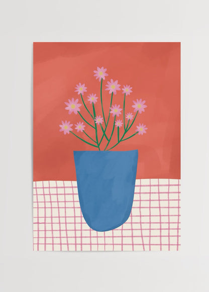 A vibrant blue pot with pink flowers against a warm background.