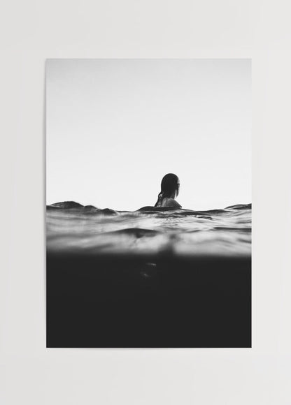 A black and white photograph of a woman in tranquil waters, representing serenity.
