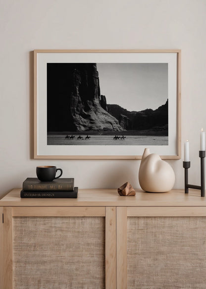 Vintage black and white poster of riders in a desert landscape.