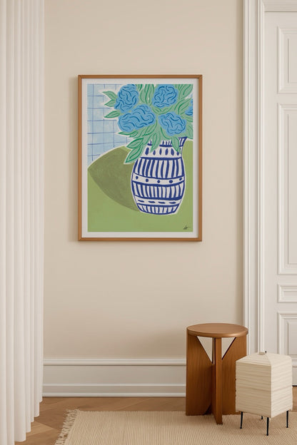 Blue hydrangeas in a patterned vase against a green background.