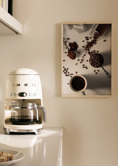 Artistic print depicting coffee preparation with beans and cup.