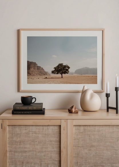 A serene desert landscape featuring a solitary tree under a clear blue sky.