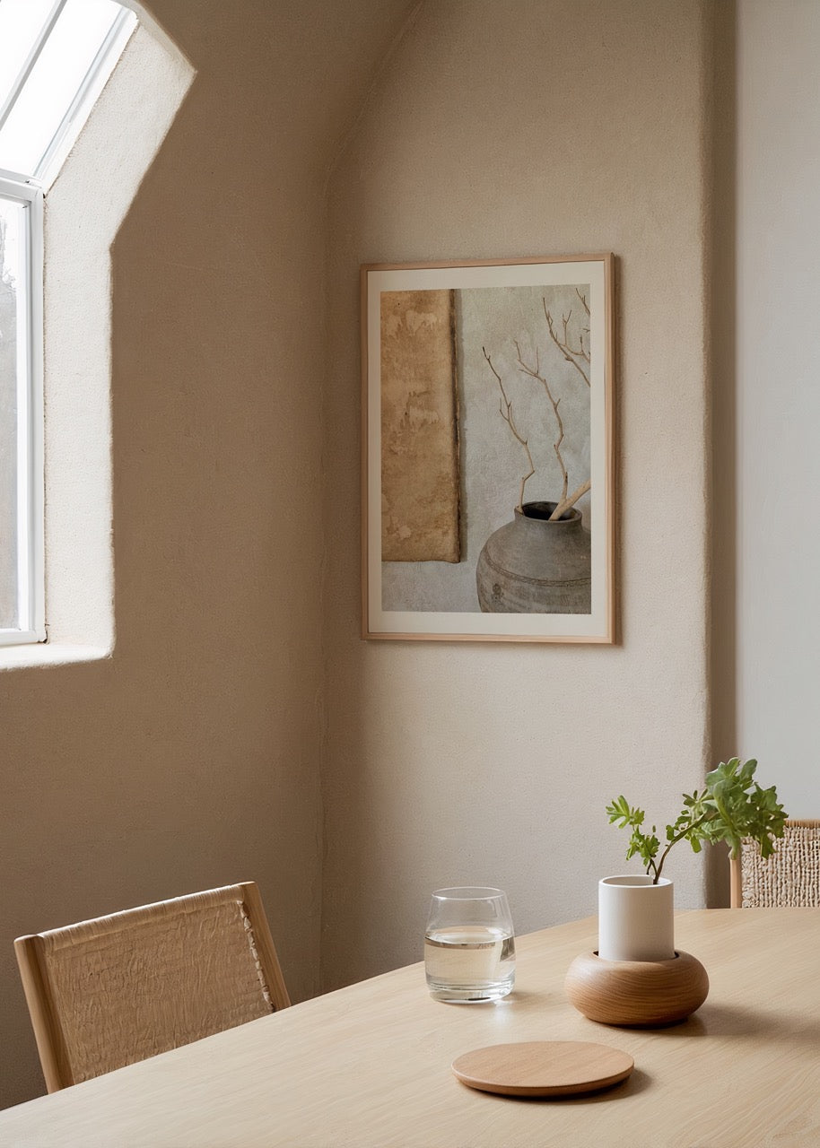 Minimalist artwork featuring a vase with branches on a textured background.