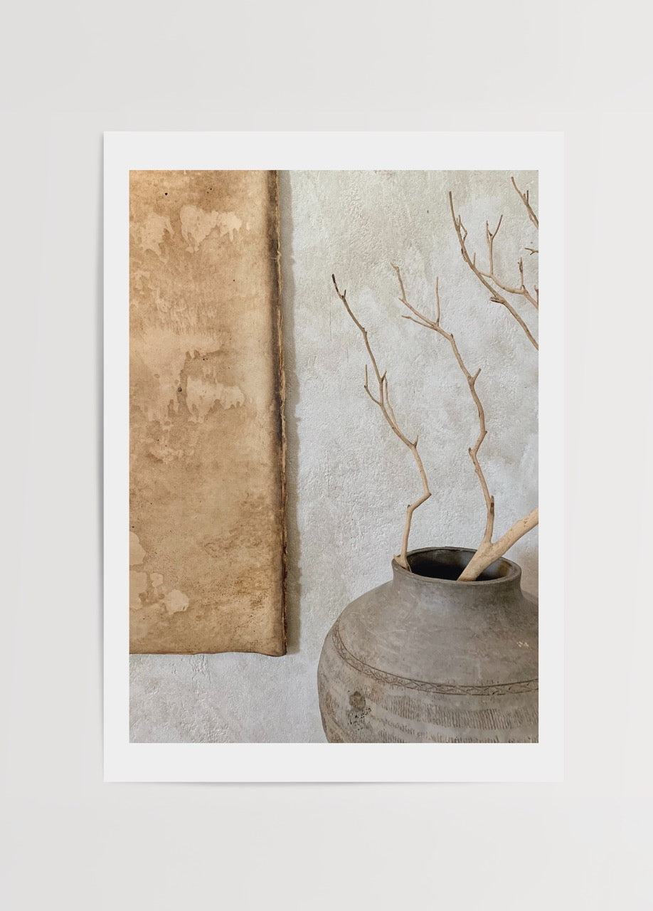 Minimalist artwork featuring a vase with branches on a textured background.