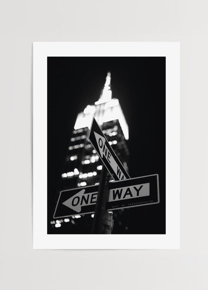 Black and white poster featuring New York street signs and skyline at night.