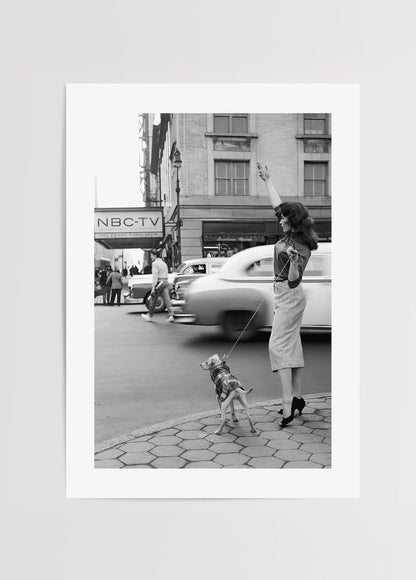A vintage black and white photograph of a woman with a dog in NYC.