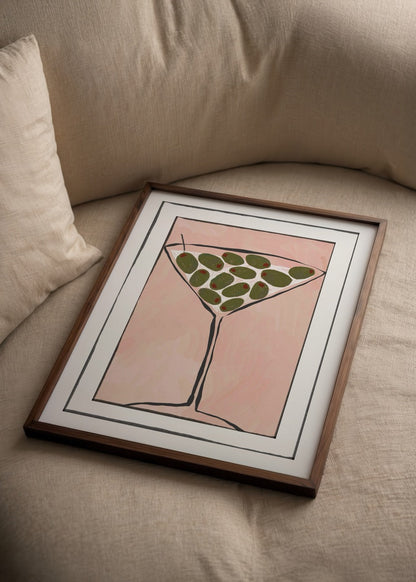 Illustration of a martini glass with olives on a pink background.
