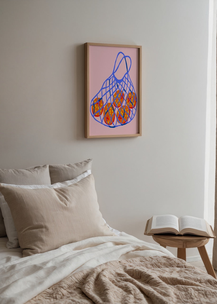 A vibrant art print of a netted basket filled with oranges on a pink background.