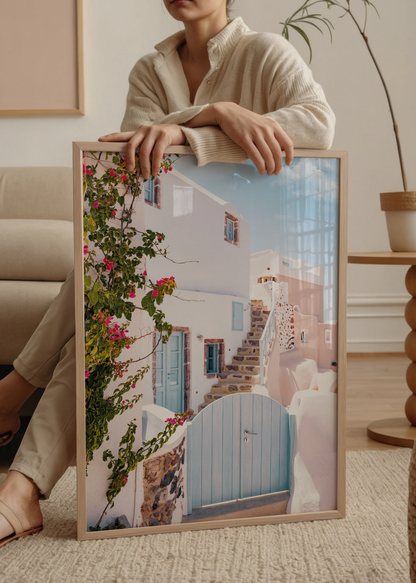 A charming view of Santorini steps with a blue door and pink flowers, perfect for wall art.