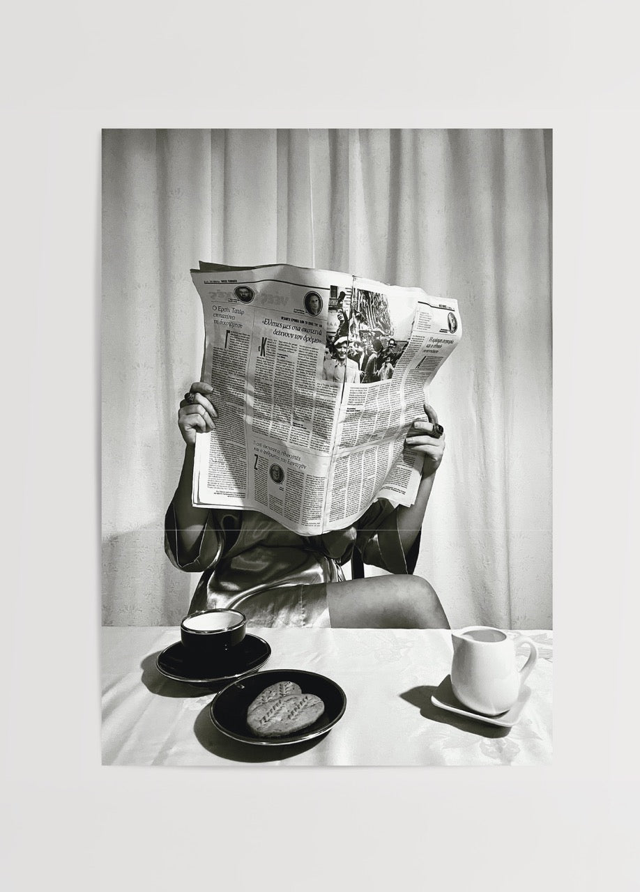 Black and white artwork of a person reading a newspaper over coffee cups and biscuits.