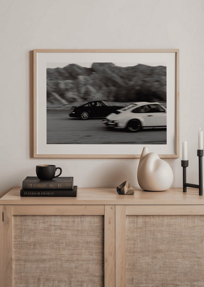 Vintage racing cars captured in dynamic motion artwork.