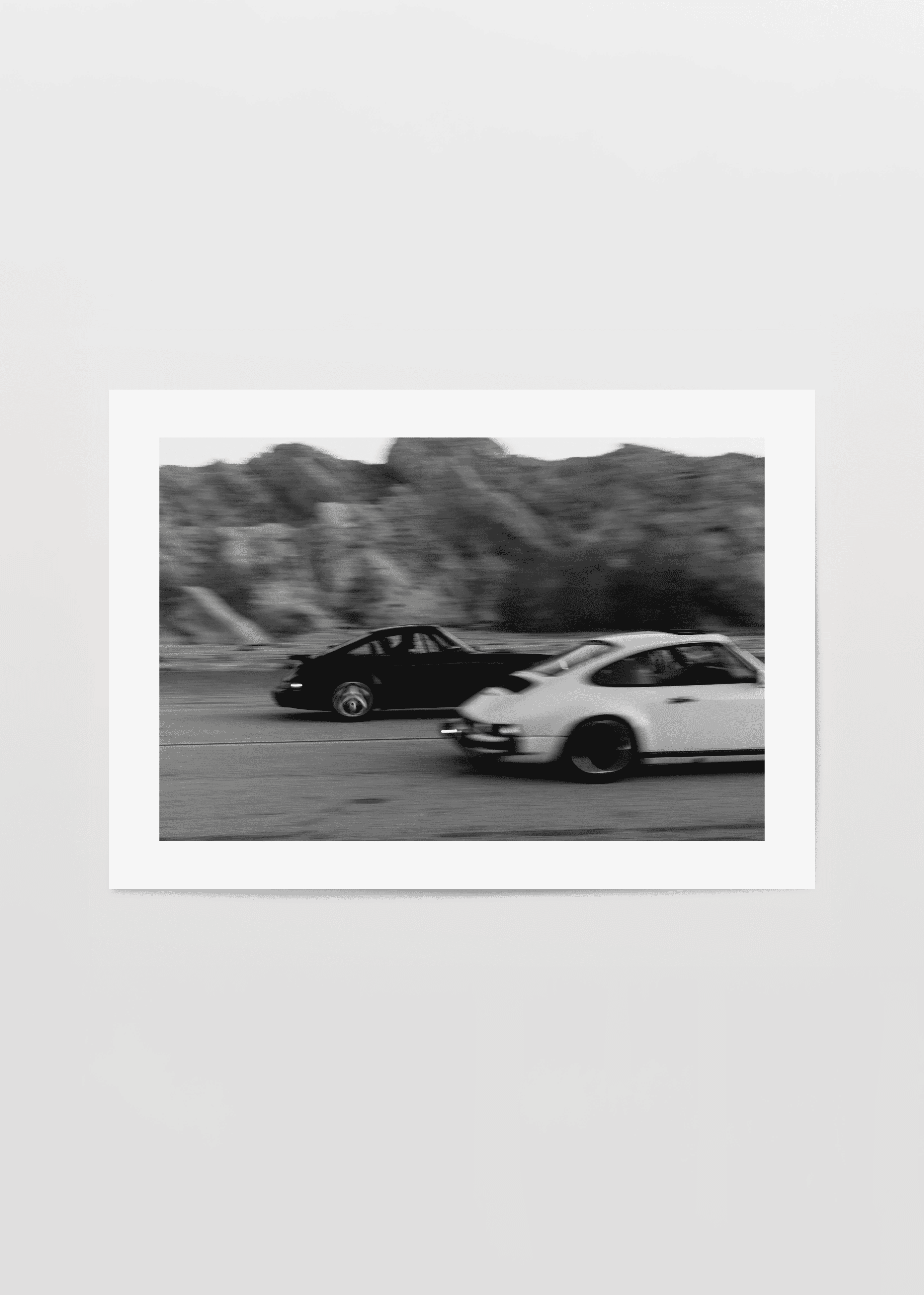 Vintage racing cars captured in dynamic motion artwork.